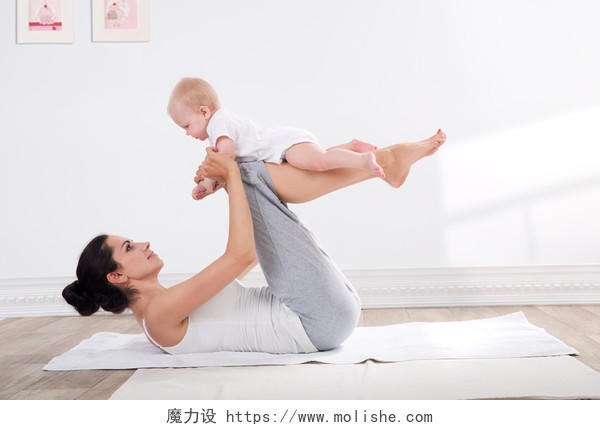 年轻的母亲与她的孩子一起锻炼身体瑜伽产后瑜伽